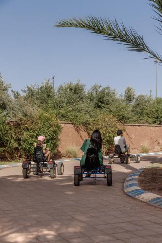 a group of people riding onicycles down a street at Barceló Palmeraie Oasis Resort in Marrakesh