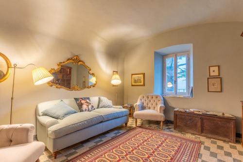 a living room with a couch and a chair and a mirror at La Rocca di Camporgiano in Camporgiano