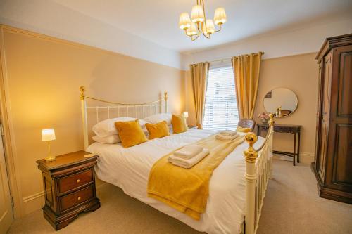 a bedroom with a large white bed with yellow pillows at Hudson House in Durham