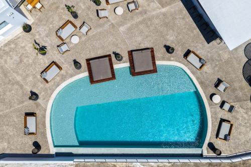 an overhead view of a swimming pool with chairs and tables at Oikos Santorini Living Concept in Fira