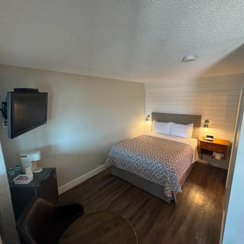 a hotel room with a bed and a flat screen tv at Motel Brise Marine in Shippagan