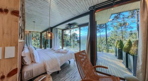 a bedroom with a bed and a large window at Rancho Canto da Lua in Urubici