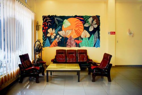 a room with chairs and a table and a painting on the wall at Collection O Banda Aceh near Masjid Raya Baiturrahman formerly Hotel Mulana in Banda Aceh