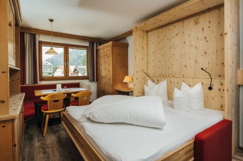 a bedroom with a large bed in a room with a table at Ferienresidenz Raich - Appartements mit Sky Wellness und Garten in Ried im Oberinntal
