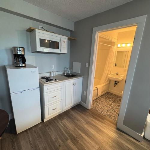 a kitchen with a white refrigerator and a sink at Motel Brise Marine in Shippagan