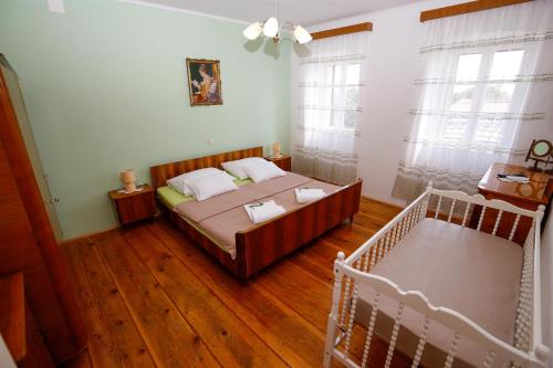 a bedroom with a bed and a crib at House Dragica in Grižane