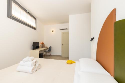 a white room with a bed and a desk at Via Tirso Rooms & Studio in Tortolì