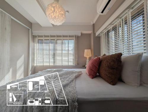a bedroom with a bed with pillows and a chandelier at LinksHotel高円寺 in Tokyo