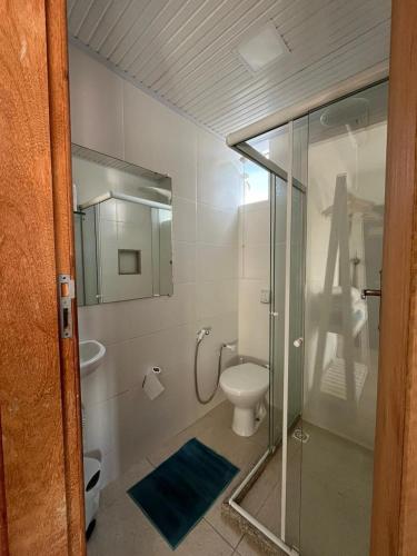 ein Badezimmer mit Toilette und Glasdusche in der Unterkunft Pousada Luz in Iriri