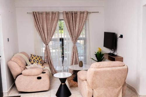 a living room with two chairs and a table at Mlambe Executive Apartments in Lilongwe