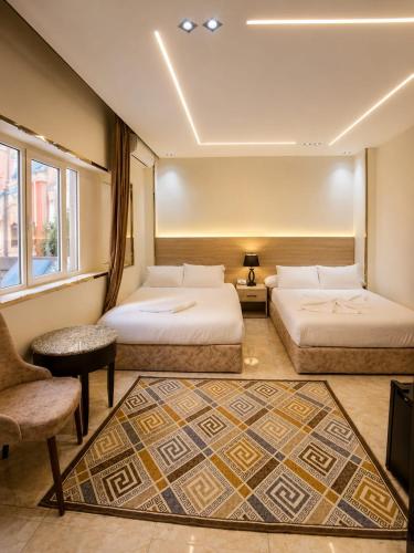 a hotel room with two beds and a chair at Pyramids Nun INN in Cairo