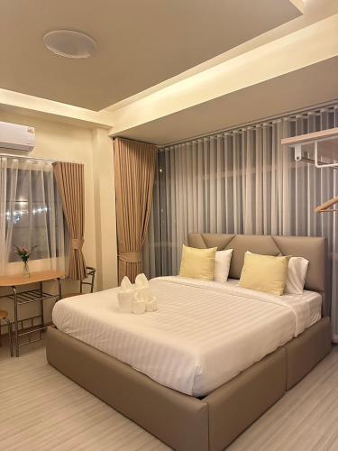 a bedroom with a large bed and a table at Full House Chiangkhan 21 in Chiang Khan
