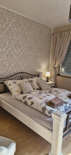 a bedroom with a large bed with a white comforter at Cityzimmer in Nettetal