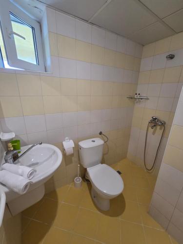a bathroom with a toilet and a sink and a shower at The Yellow House in Ahtopol