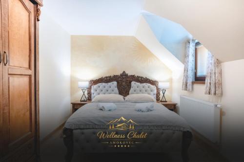 a bedroom with a bed with a mattress club sign on it at Wellness chalet Smokovec in Vysoké Tatry
