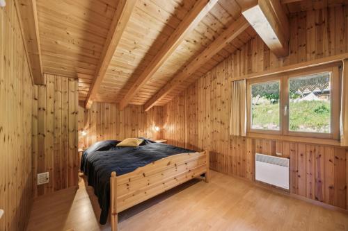 a bedroom in a log cabin with a bed in it at Chalet Siesta OG in Bellwald
