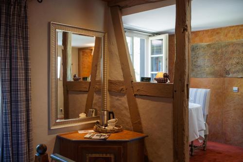 a bathroom with a sink and a mirror on the wall at Hôtel le Moulin in Gundershoffen