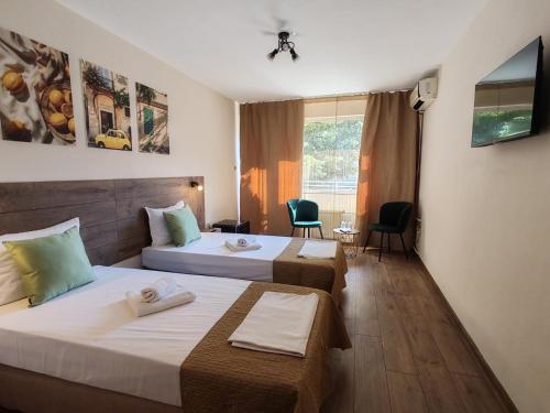 a hotel room with two beds and a window at Hotel Sorbona in Varna City
