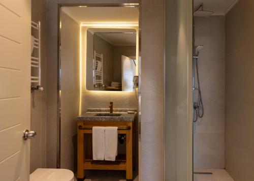 a bathroom with a sink and a toilet and a mirror at BoStay Hotel in Istanbul