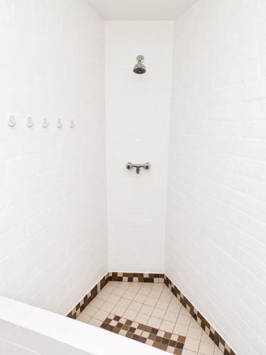 a bathroom with a shower with a tiled floor at Dwarskersbos,Skilliepark in Velddrif