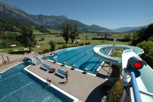 a large swimming pool with a water slide at Alpenlodge Haus - Summer resort with Schladming-Dachstein Card in Haus im Ennstal