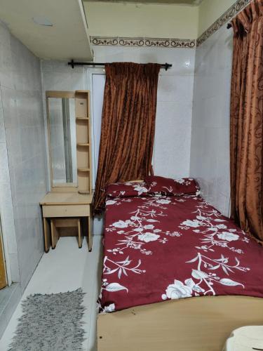 a bedroom with a bed and a table and a mirror at Sri Sai Lodge in Palni