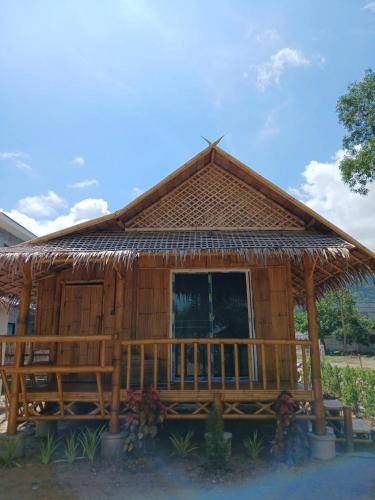 a house with a thatched roof and a porch at Long Beach Bamboo House in Ban Ai Dao