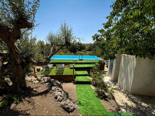 a garden with green grass and a swimming pool at White House R&B in Campobello di Licata