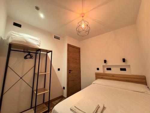 a bedroom with a bed and a chandelier at Casa Ara Montanejos in Montanejos