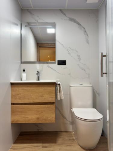 a bathroom with a toilet and a sink and a mirror at Casa Ara Montanejos in Montanejos