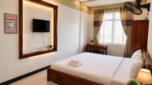 a bedroom with a bed with a mirror and a television at Motel Đại Phát Đạt in Cù Lao Tâu
