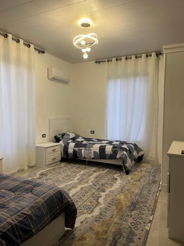 a bedroom with two beds and a window at Suf Hills Cabin in Jerash
