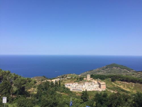 a building on top of a hill next to the ocean at Mini Hotel in Orbetello