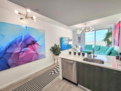 a kitchen with a large painting on the wall at Electric Luxury Downtown Bayfront Brickell in Miami