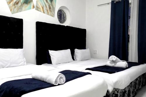 two beds in a hotel room with towels on them at Goshen Lodge Goodwood in Goodwood