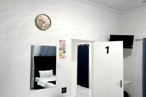 a white room with a clock on the wall at Goshen Lodge Goodwood in Goodwood
