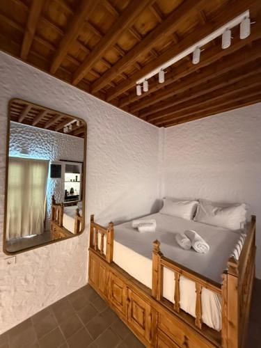 a bedroom with a large bed with a mirror at Apollino Lindos in Lindos
