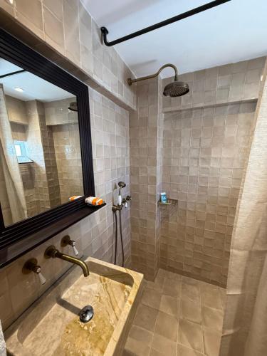 a bathroom with a sink and a mirror at Apollino Lindos in Lindos