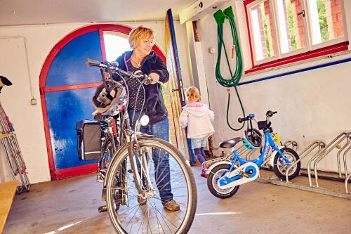 a woman standing next to a bike in a room at DJH Jugendherberge Hagen in Hagen