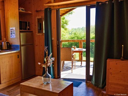a kitchen with a sliding glass door to a deck at Tiny house - Cabane sur pilotis - Etat Nature in Magnières