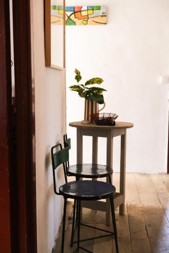 a chair next to a table with a plant on it at Cal Mengo in La Vega