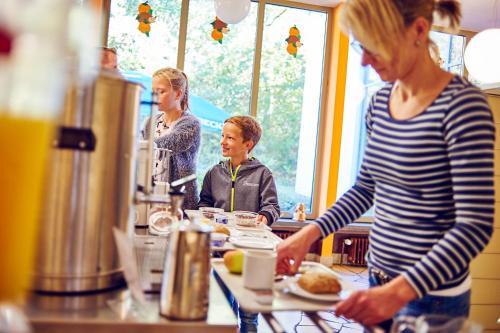 a woman standing in front of a table with a plate of food at DJH Jugendherberge Hagen in Hagen