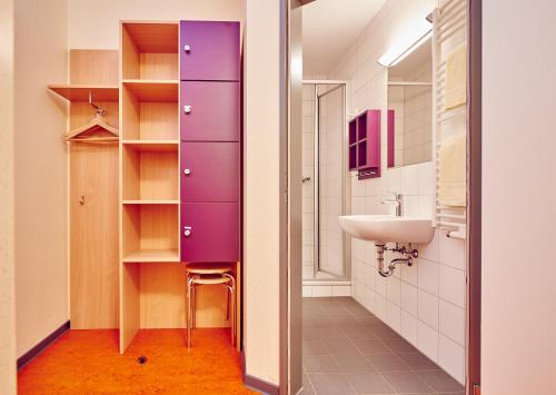łazienka z fioletową szafką i umywalką w obiekcie DJH Jugendherberge Hagen w mieście Hagen
