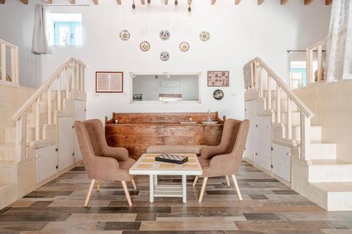 a living room with two chairs and a table at Stefanis Relis House in Archangelos