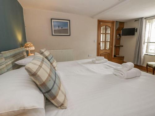 a large white bed with two towels on it at Dewi Villa Apartment in Aberaeron