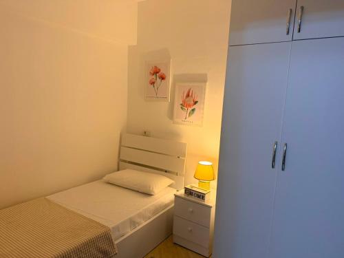 a small bedroom with a bed and a cabinet at ASA Apartament in Tirana