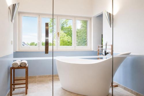 a white tub in a bathroom with a window at Landhaus Gernitz in Seedorf