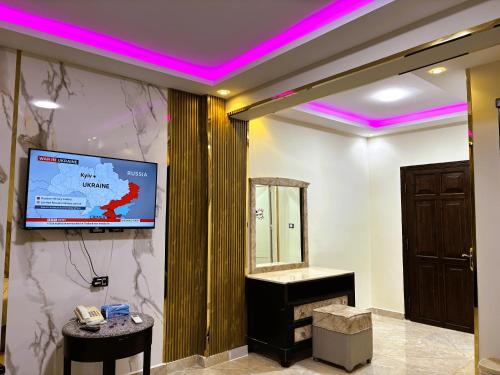 a room with a tv on a wall with purple lights at Pyramids Nun INN in Cairo