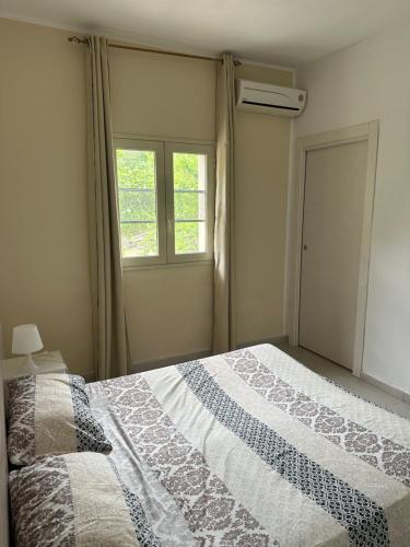 a bedroom with a large bed and a window at Casa vacanza le tre palme in Syracuse
