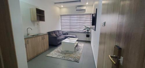 ein kleines Wohnzimmer mit Sofa und Tisch in der Unterkunft Hotel Capitol in Ikeja